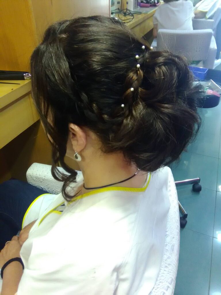 Peinado recogido bajo con trenza y detalle decorativo